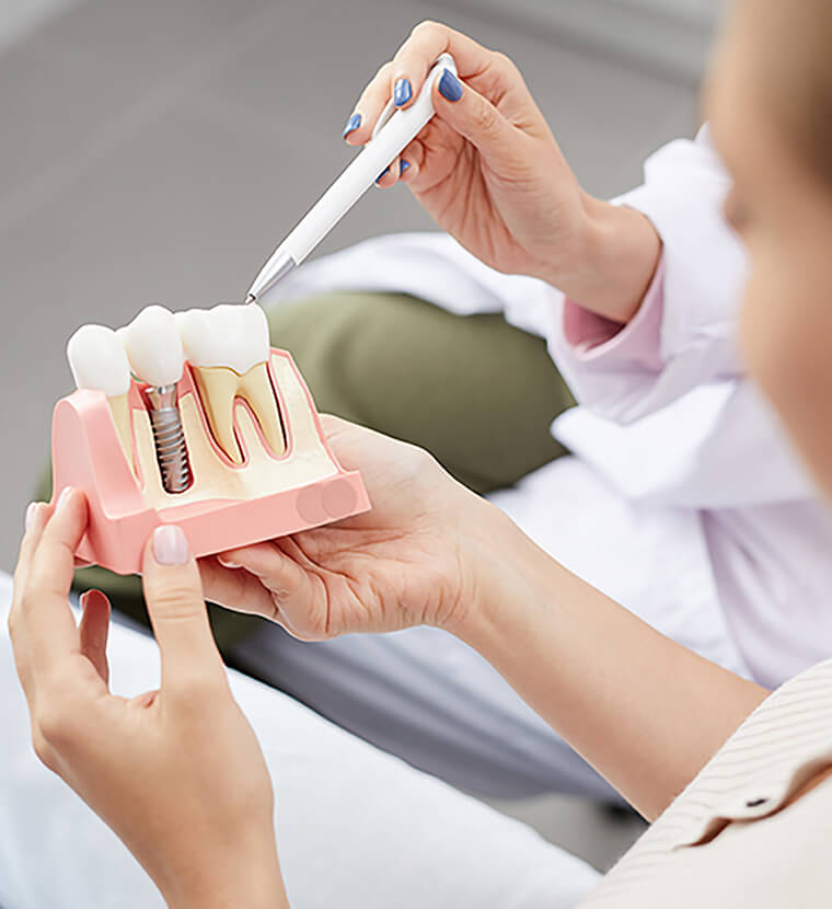 dental patient looking at a 3-D model of a dental implant