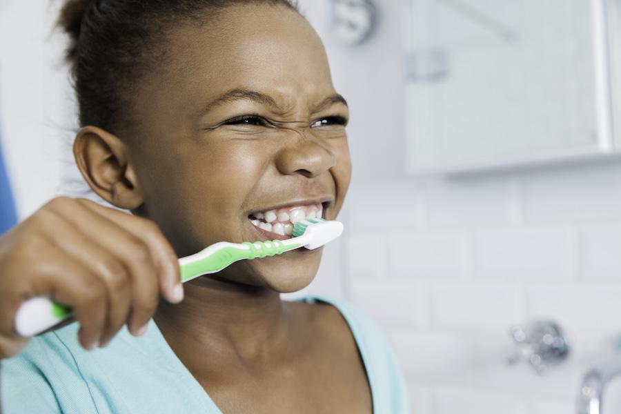 young girl brushing to prevent cavities in children